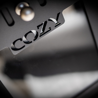 Close-up of a metallic surface with 'COZY' engraved on it.
