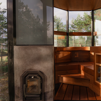 Wooden sauna with a stone wall and large windows overlooking trees