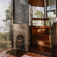 Wooden sauna interior with glass walls and a metal stove.