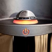 Close-up of a grill with a glowing burner and power symbol