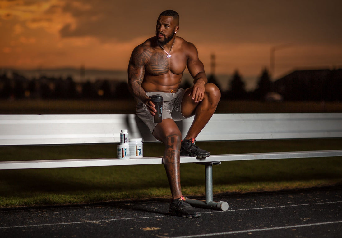 Athlete resting on a track bench at sunset after training