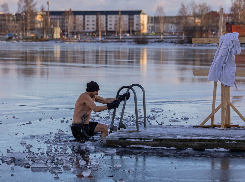 Person in cold water immersion in a wintry setting, representing cold therapy for inflammation.