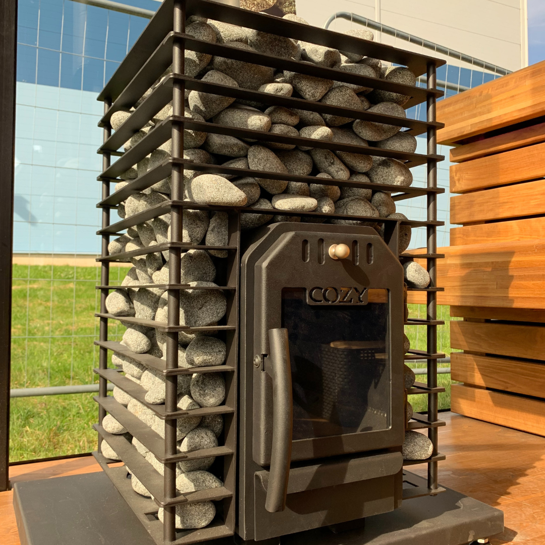 Outdoor wood stove with stone chimney in a garden setting