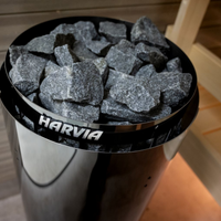 Container of charcoal with 'Harvia' branding on a wooden surface