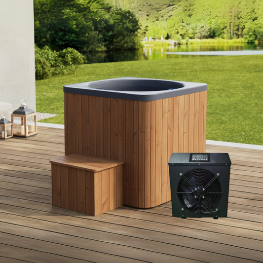 An ice bath tub with a wooden exterior, black interior lining, accompanied by a wooden chiller and a small wooden bench, set on a wooden deck with a scenic background.