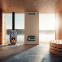 A modern sauna heater with visible flames, installed on a white floor next to a large window with a scenic view of a body of water and a wood-paneled wall.