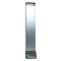 Tall metallic vending machine with a reflective surface, standing against a black background. It dispenses cigarettes, visible through a clear front panel.